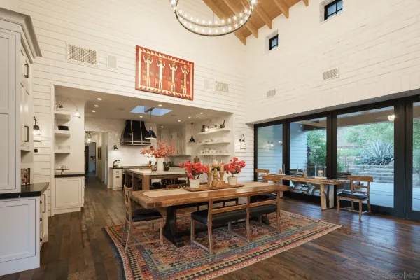 a dining room with furniture and large windows