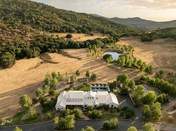 an aerial view of residential houses with outdoor space and trees