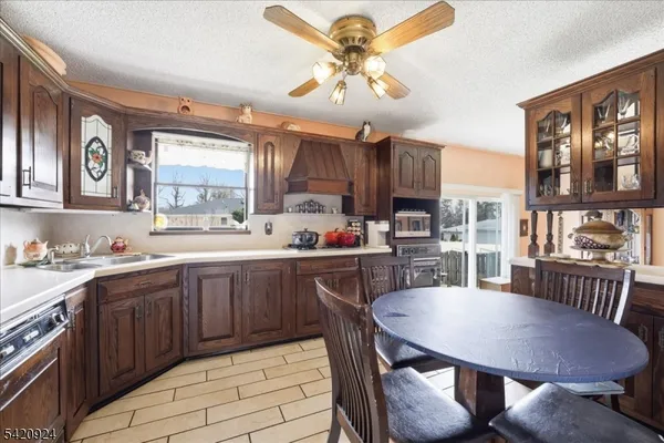 a kitchen with a dining table chairs cabinets and stainless steel appliances