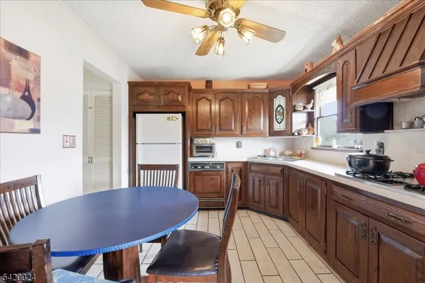a kitchen with stainless steel appliances granite countertop a sink dishwasher a stove a refrigerator with a dining table and chairs
