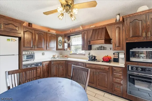 a kitchen with stainless steel appliances granite countertop a sink dishwasher stove and cabinets with wooden floor