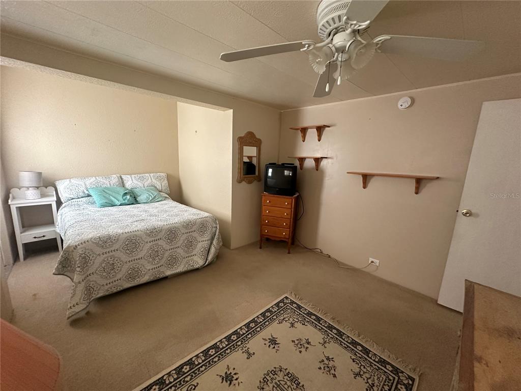 5791 Orange Blossom Road Venice, FL 34293 - Photo 9 of 24 a bedroom with a bed and a chandelier