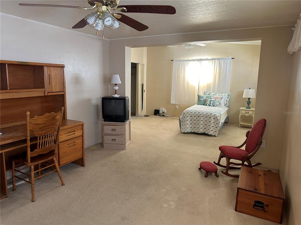5791 Orange Blossom Road Venice, FL 34293 - Photo 10 of 24 a hallway with furniture and a flat screen tv