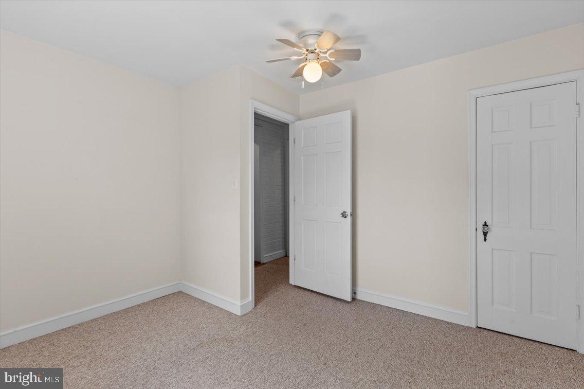 6023 Walhonding Road Bethesda, MD 20816 - Photo 13 of 37 an empty room with a ceiling fan and a window