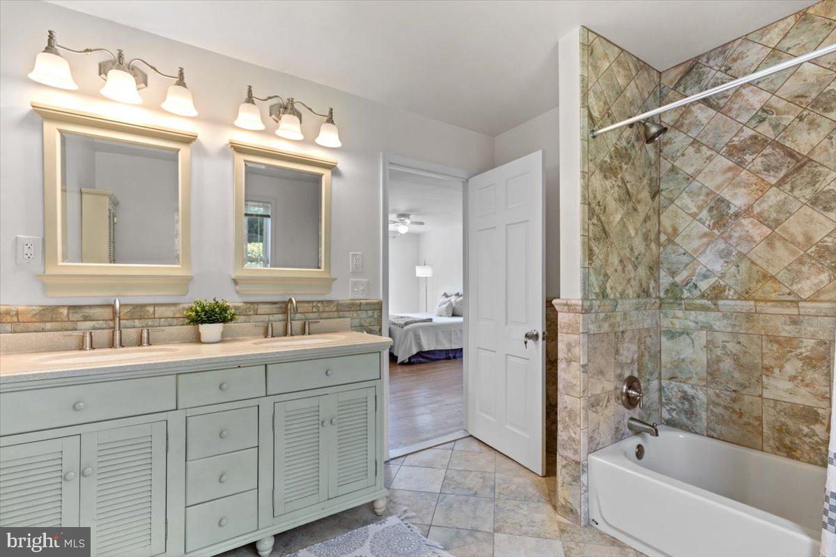 6023 Walhonding Road Bethesda, MD 20816 - Photo 26 of 37 a bathroom with a double vanity sink mirror and bathtub
