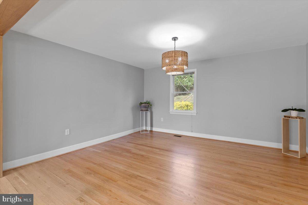 6023 Walhonding Road Bethesda, MD 20816 - Photo 9 of 37 a view of empty room with window and wooden floor