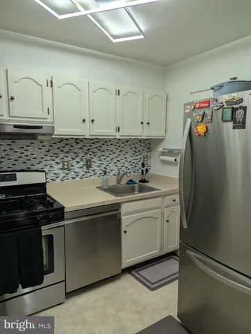 a kitchen with stainless steel appliances granite countertop a stove and a refrigerator