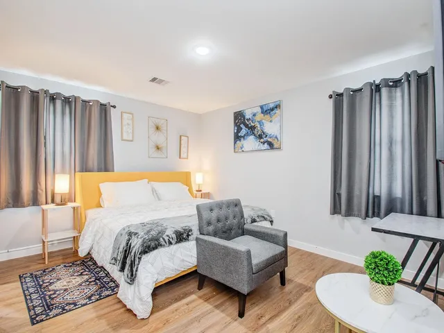 a bedroom with a bed couch and a potted plant