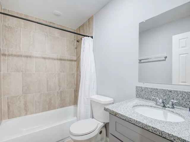 a bathroom with a granite countertop sink toilet and shower