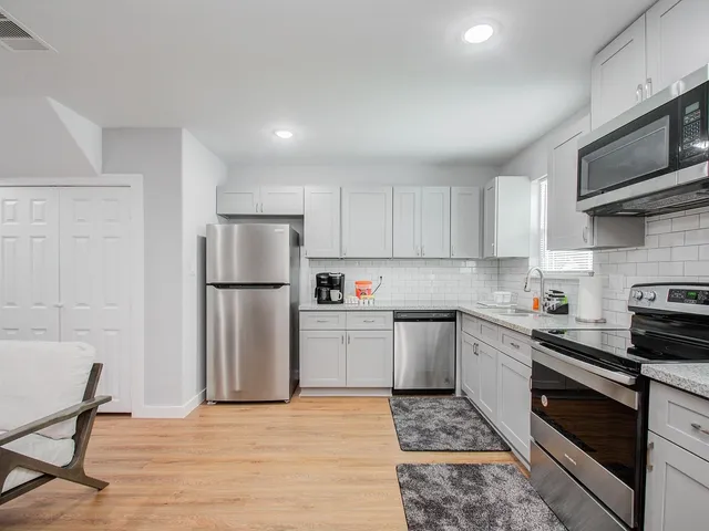a kitchen with granite countertop a refrigerator and a stove top oven