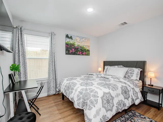 a bed sitting in a bedroom next to a window