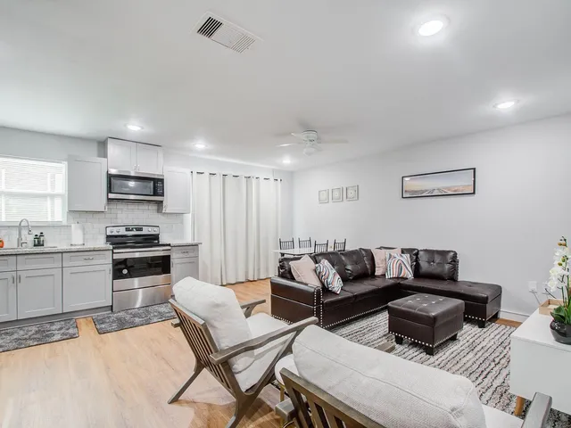 a living room with furniture and a wooden floor