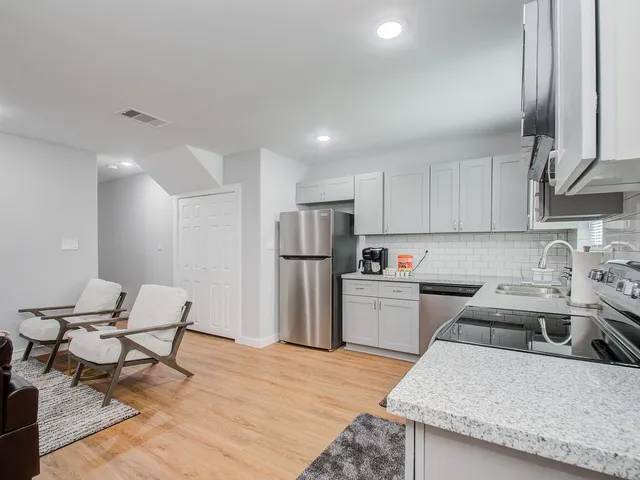 a kitchen with refrigerator and chairs