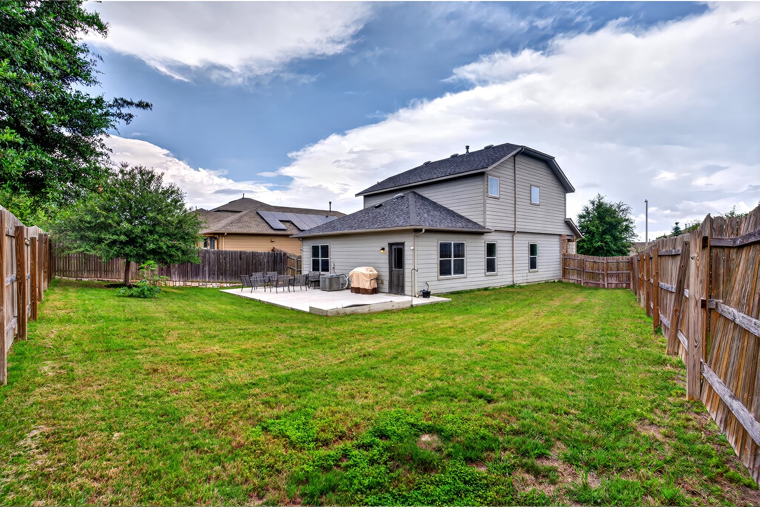 2006 Grow Lane Austin, TX 78754 - Photo 25 of 40 A spacious backyard with mature trees and a fenced perimeter offers a large patio for outdoor entertaining.