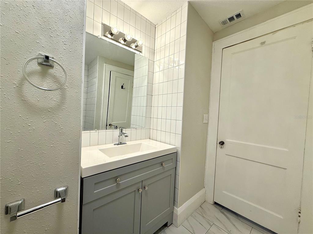 4015 North Seminole Avenue, Unit 2 Tampa, FL 33603 - Photo 13 of 17 a bathroom with a sink a mirror and a shower