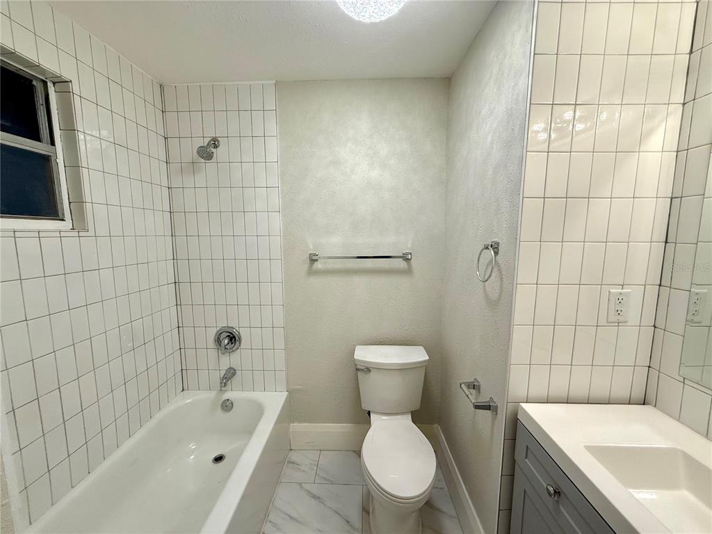 4015 North Seminole Avenue, Unit 2 Tampa, FL 33603 - Photo 14 of 17 a white toilet sitting next to a bath tub and shower