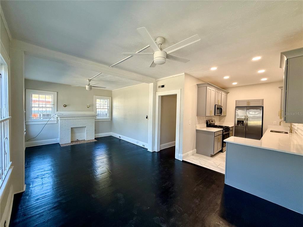 4015 North Seminole Avenue, Unit 2 Tampa, FL 33603 - Photo 5 of 17 a view of a big room with wooden floor and a kitchen