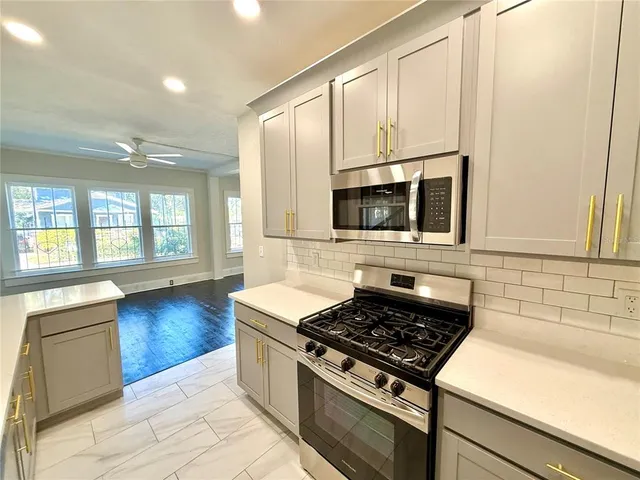 a kitchen with stainless steel appliances a stove a microwave and cabinets