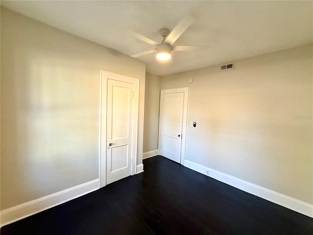 4015 North Seminole Avenue, Unit 2 Tampa, FL 33603 - Photo 10 of 17 an empty room with wooden floor and windows