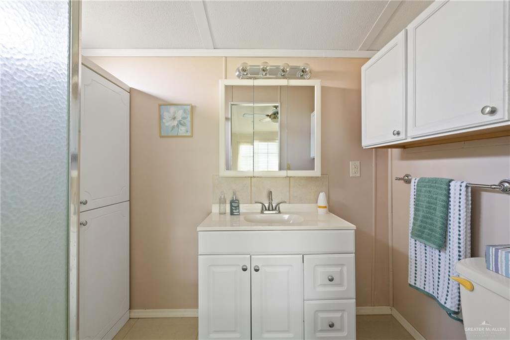 27516 Glenview Road Rio Hondo, TX 78583 - Photo 12 of 26 Bathroom featuring vanity, tasteful backsplash, and light tile patterned flooring