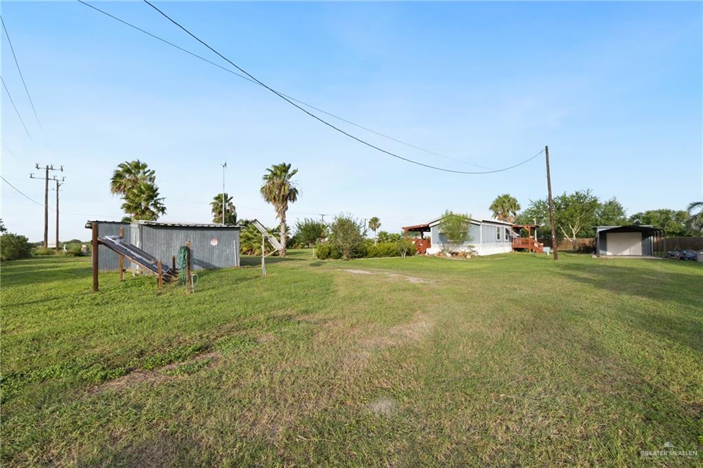 27516 Glenview Road Rio Hondo, TX 78583 - Photo 19 of 26 View of green lawn with an outdoor structure and a detached carport