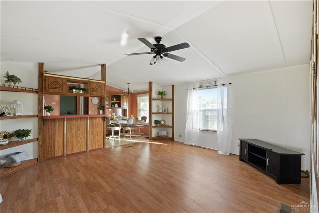 27516 Glenview Road Rio Hondo, TX 78583 - Photo 3 of 26 Unfurnished living room featuring vaulted ceiling, light wood-type flooring, and a ceiling fan