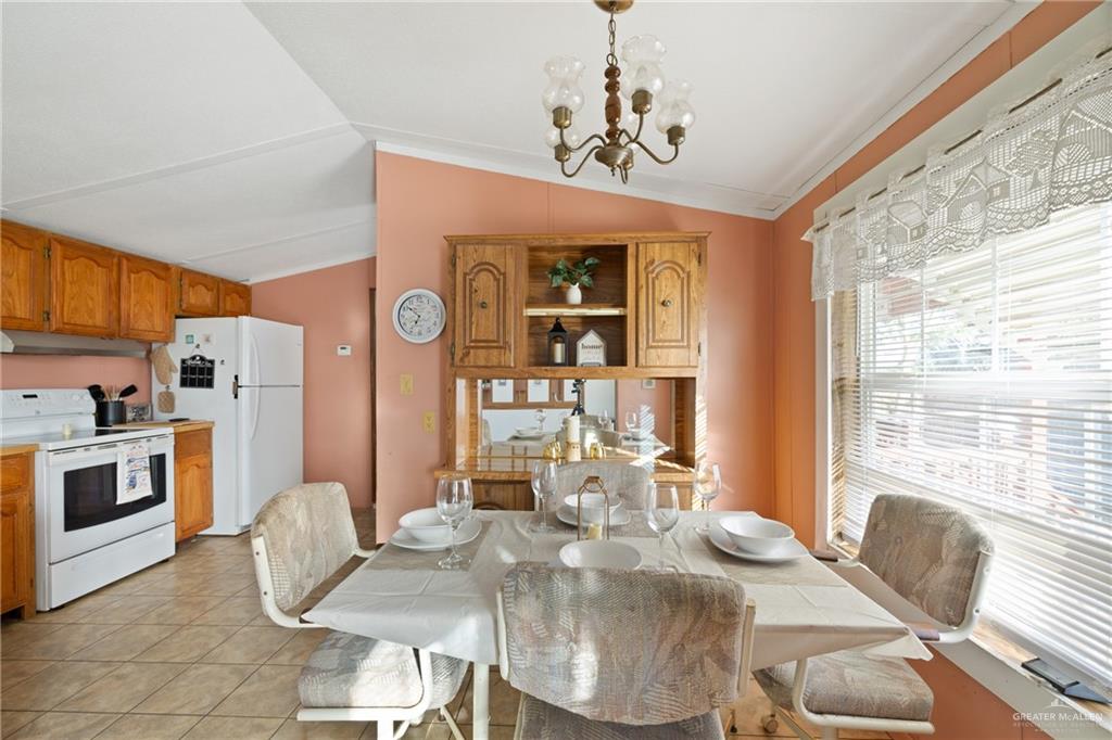 27516 Glenview Road Rio Hondo, TX 78583 - Photo 8 of 26 Dining space with vaulted ceiling, a chandelier, and light tile patterned floors