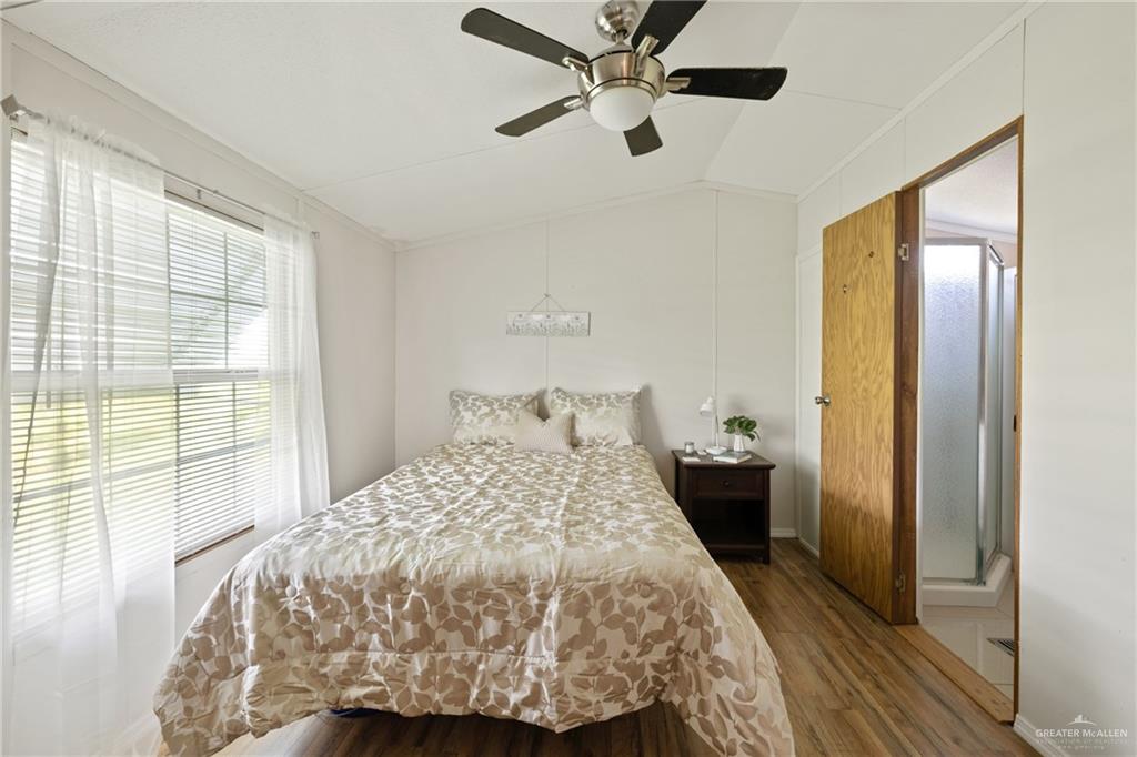 27516 Glenview Road Rio Hondo, TX 78583 - Photo 10 of 26 Bedroom featuring dark wood-style floors, vaulted ceiling, and a ceiling fan