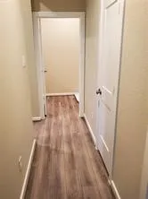 a view of a room with wooden floor and a bathroom