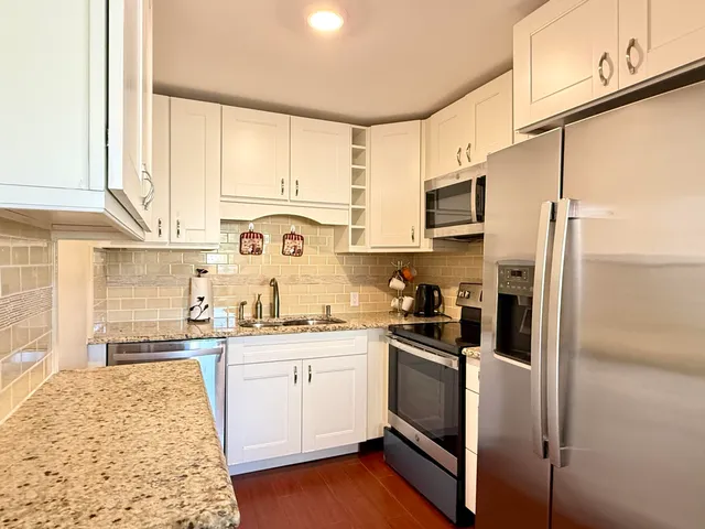 a kitchen with stainless steel appliances granite countertop a refrigerator sink and cabinets