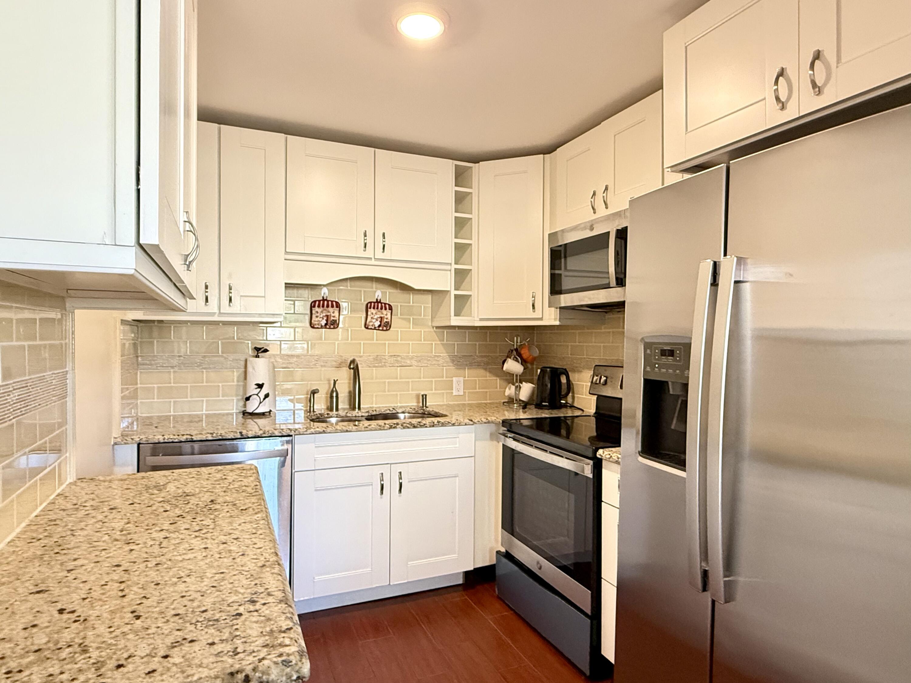 a kitchen with stainless steel appliances granite countertop a refrigerator sink and cabinets
