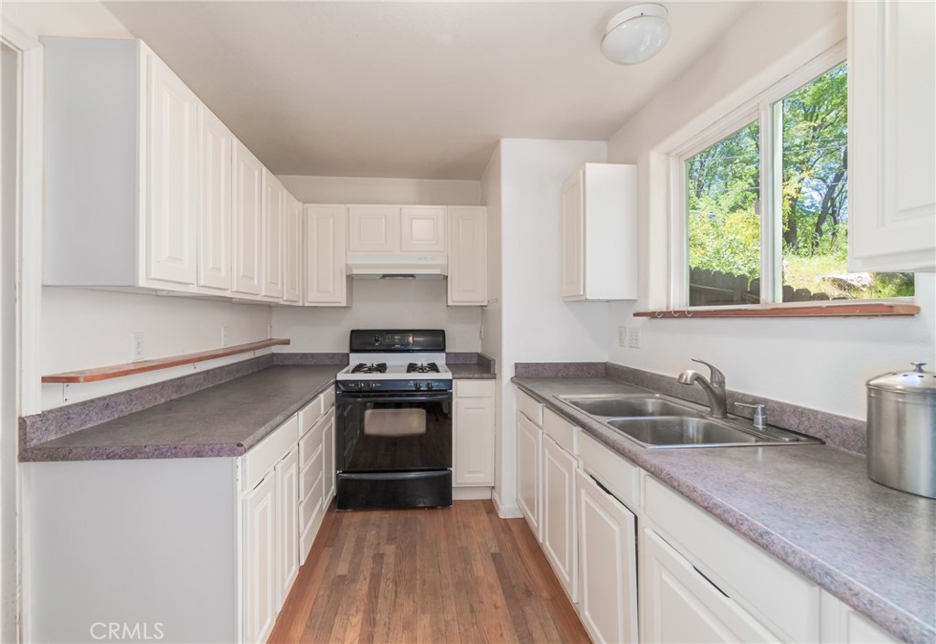 11575 Loch Lomond Road Middletown, CA 95461 - Photo 16 of 38 a kitchen with a sink stove top oven and cabinets