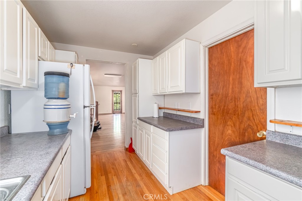 11575 Loch Lomond Road Middletown, CA 95461 - Photo 17 of 38 a kitchen with a sink a stove cabinets and wooden floor