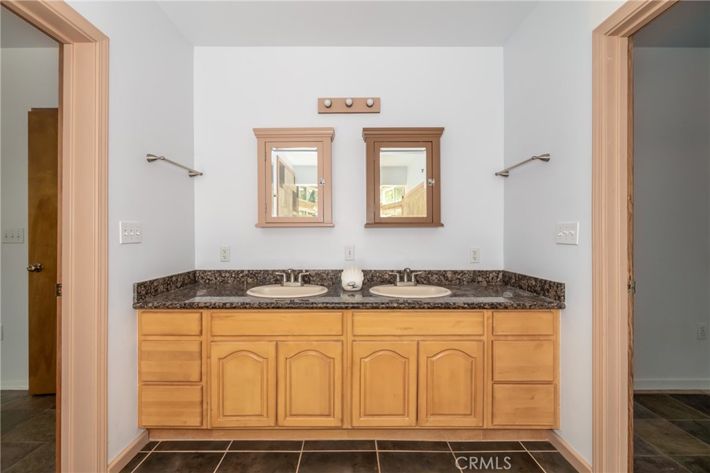 11575 Loch Lomond Road Middletown, CA 95461 - Photo 23 of 38 a bathroom with a granite countertop sink and a mirror
