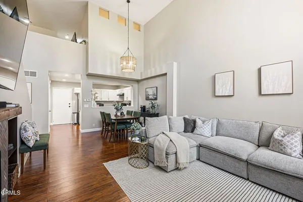 a living room with furniture a wooden floor and a chandelier