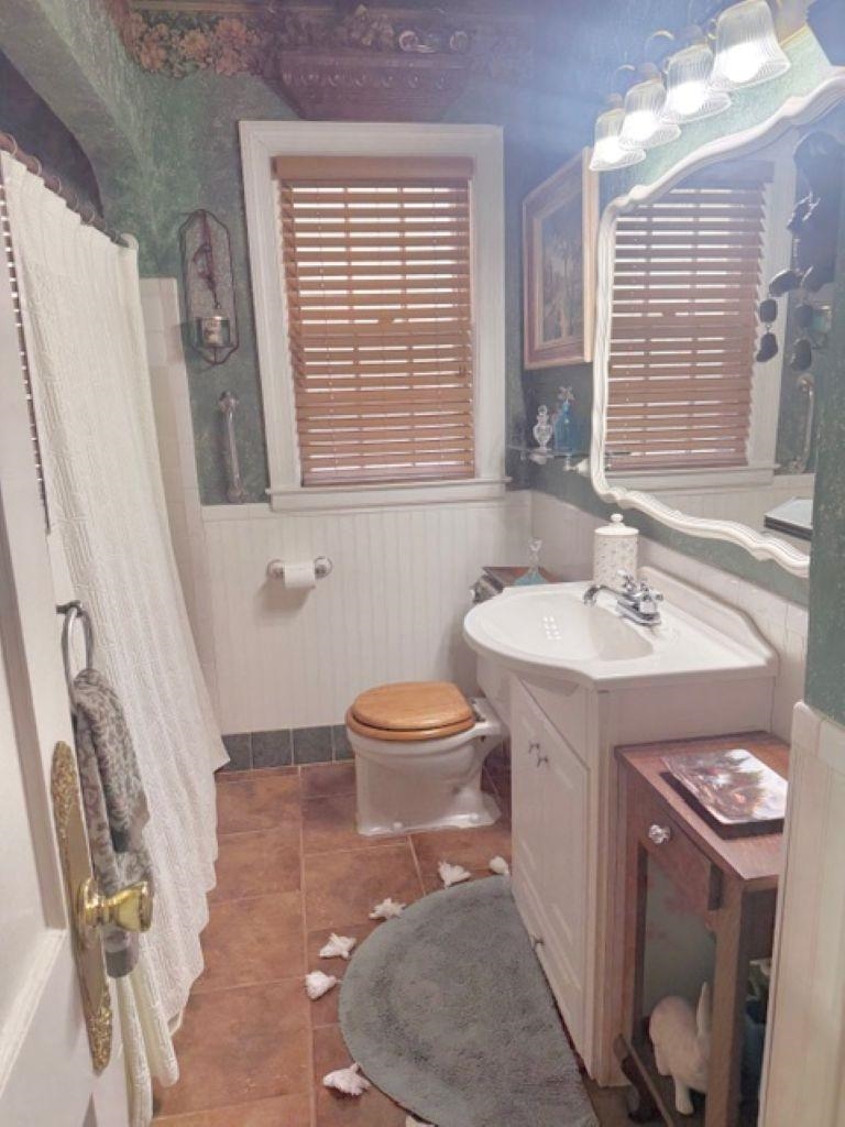 829 North Perkins Road Memphis, TN 38122 - Photo 18 of 36 Hallway Full bathroom featuring a wainscoted wall, vanity, curtained shower, and tile patterned flooring