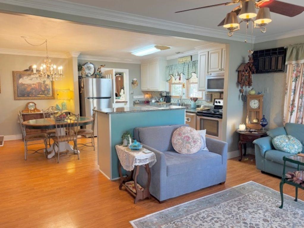 829 North Perkins Road Memphis, TN 38122 - Photo 4 of 36 Living room with ornamental molding, ceiling fan, suspended lighting, and light wood-style floors