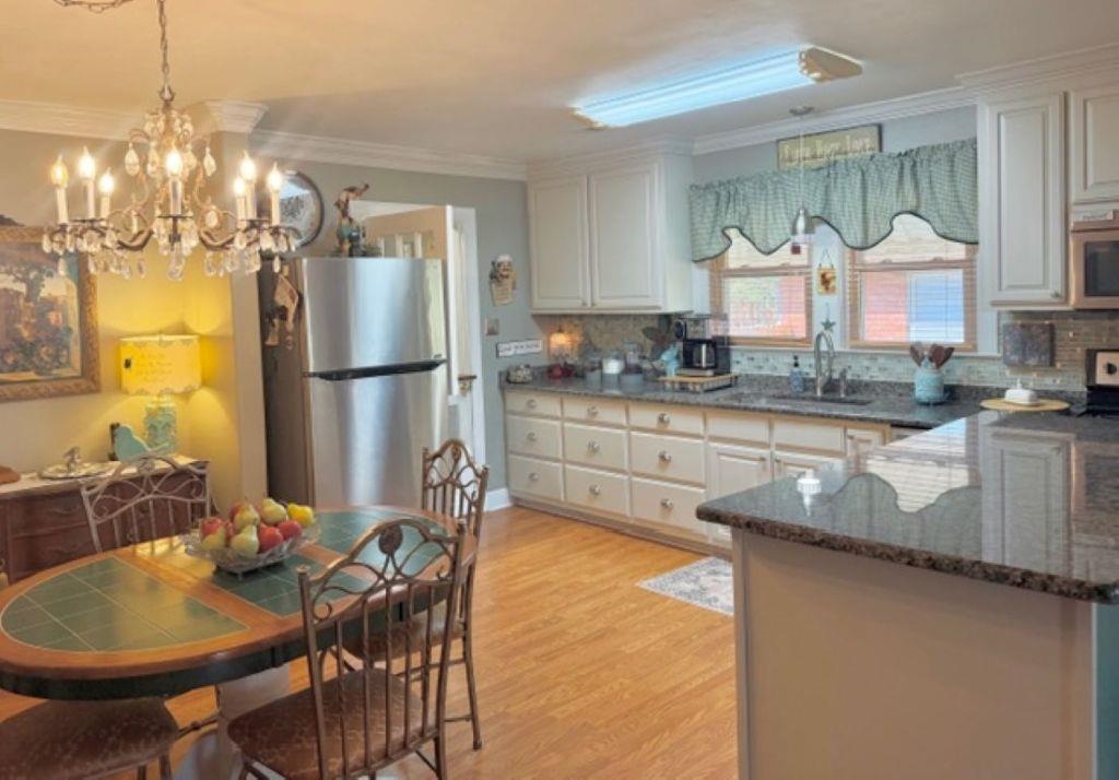 829 North Perkins Road Memphis, TN 38122 - Photo 5 of 36 Kitchen with stainless steel appliances, dark stone counters, backsplash, crown molding, and light wood-style flooring