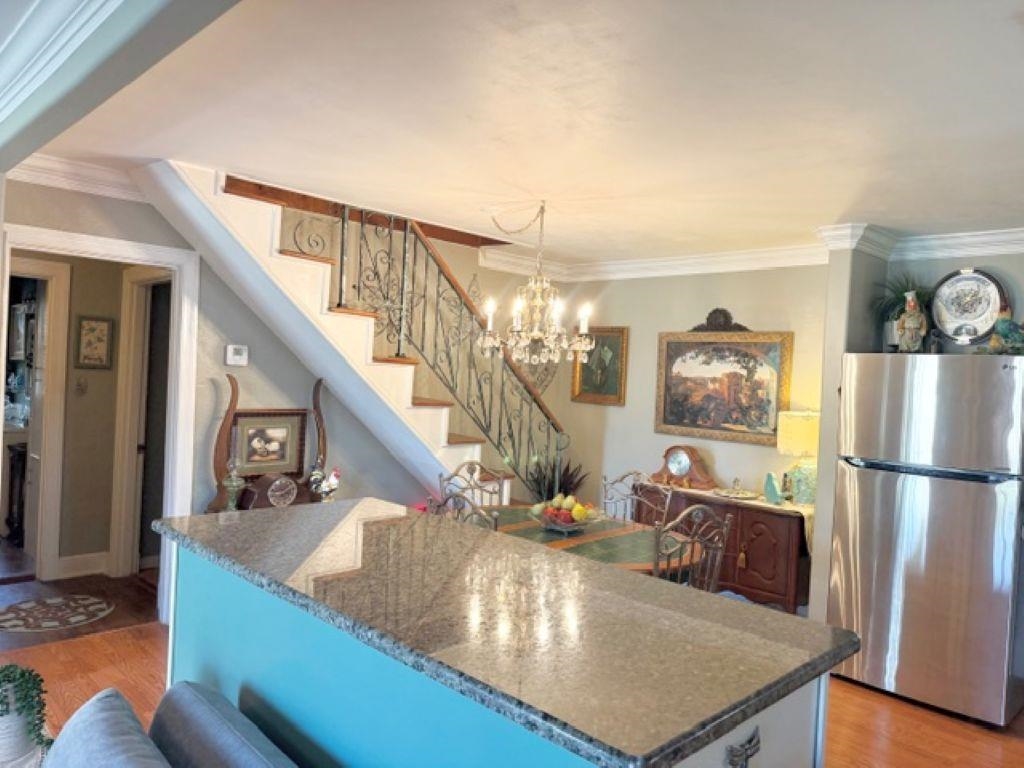 829 North Perkins Road Memphis, TN 38122 - Photo 6 of 36 Kitchen featuring ornamental molding, freestanding refrigerator, light wood finished floors, and dark stone counters