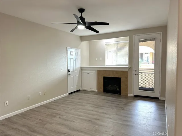 wooden floor fireplace and windows in an empty room