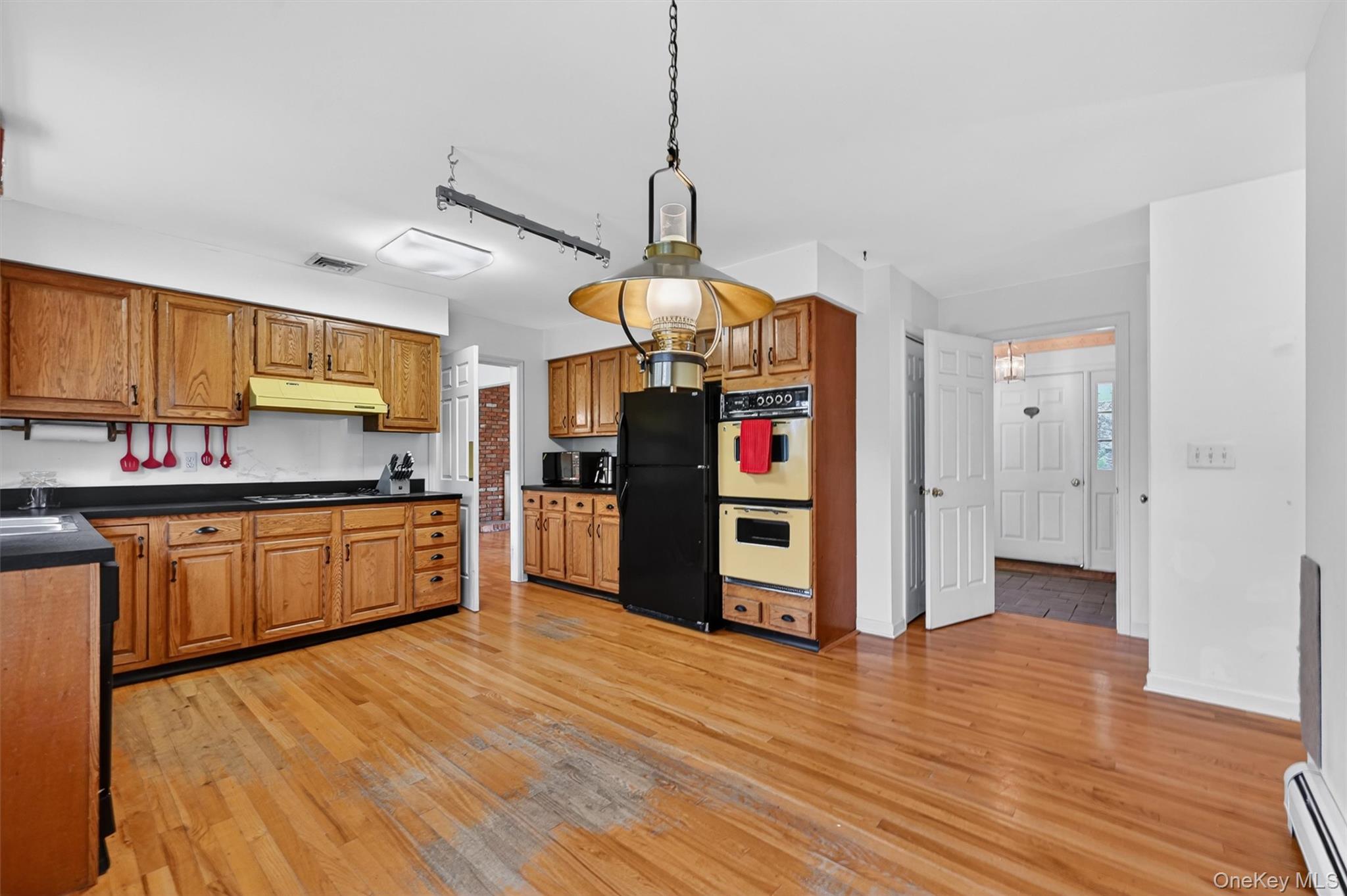 16 Ridgeview Terrace Goshen, NY 10924 - Photo 11 of 35 Kitchen featuring wood cabinetry, black countertops, wood-finish flooring, and a built-in double oven