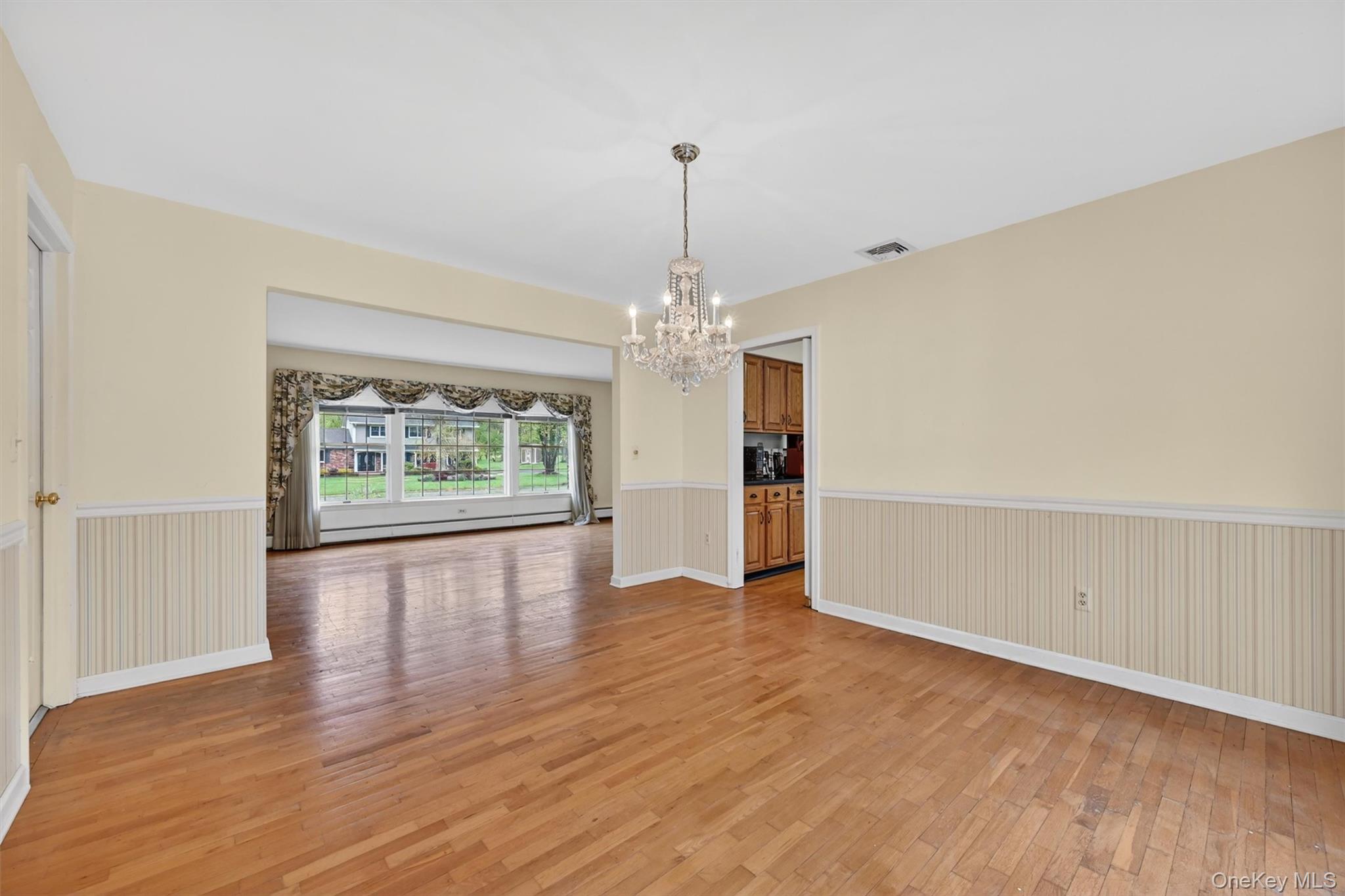 16 Ridgeview Terrace Goshen, NY 10924 - Photo 8 of 35 Hardwood flooring extends throughout this space, complemented by wainscoting and a chandelier