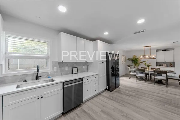 a kitchen that has a lot of cabinets a sink and appliances in it