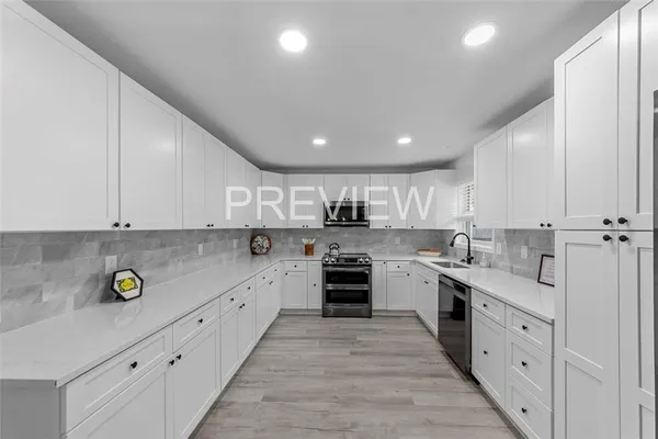 a large kitchen with stainless steel appliances granite countertop a lot of counter space and wooden floors