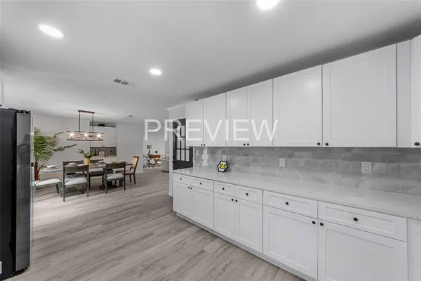a kitchen with white cabinets and sink