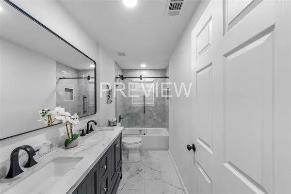 a bathroom with a granite countertop sink a toilet and shower