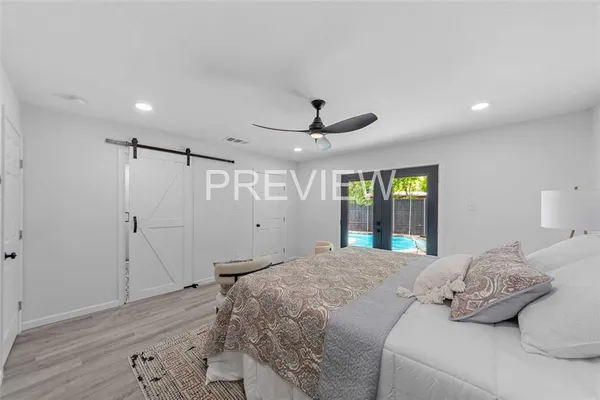 a bedroom with a large bed and a wooden floor