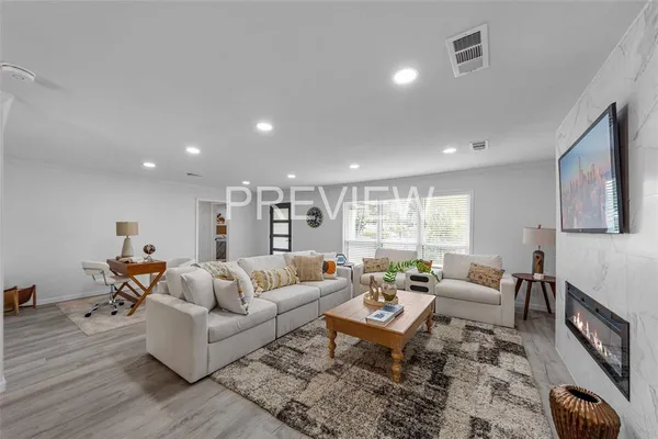 a living room with furniture wooden floor and a large window