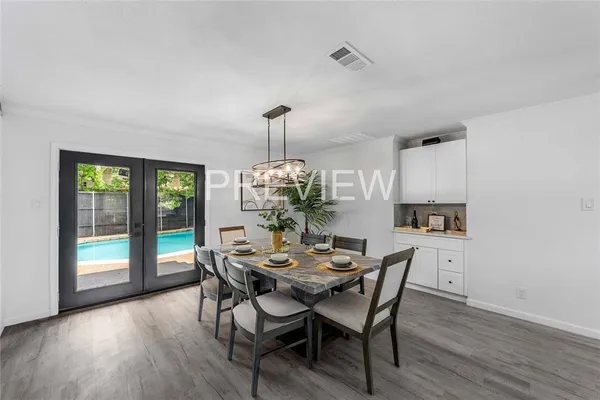 a dining room with furniture a chandelier and wooden floor