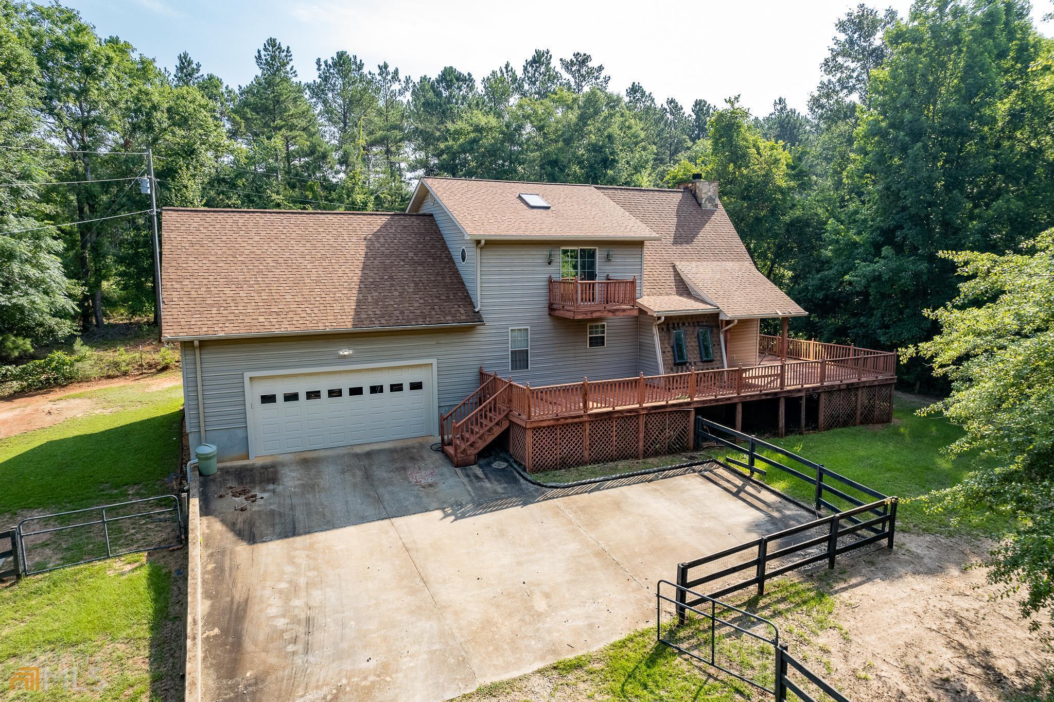 a view of a white house with a yard table and chairs